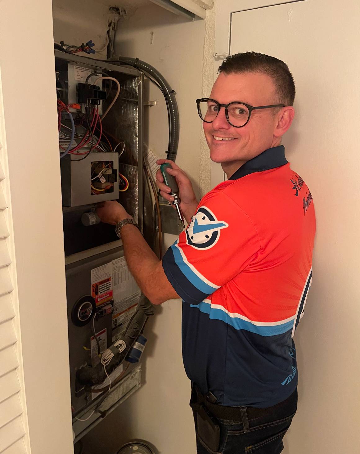 Climate Control Services Expert Technician performing Annual AC maintenance on an HVAC system